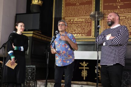 Three poets performing in a church