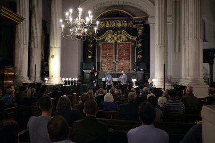 Three poets performing in a church