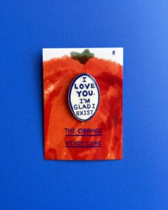 'The Orange' pin badge on a blue background